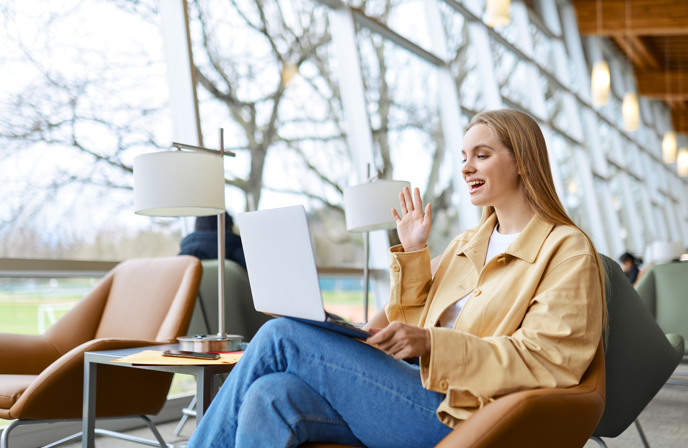 Young woman having a meeting in a public area on a laptop - multi-vendor hybrid office meeting room experience