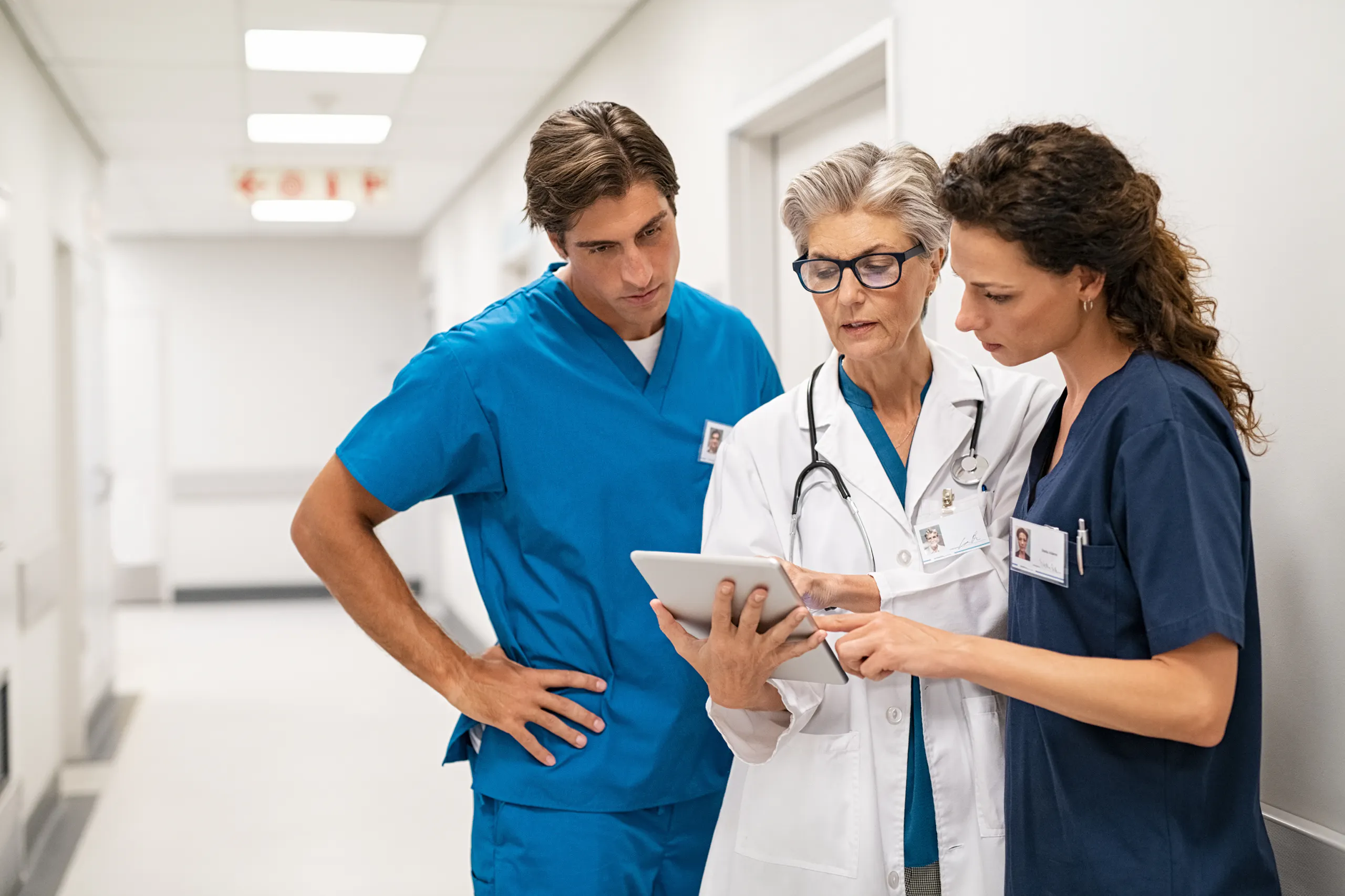 Healthcare consultants discussion in hospital corridor Successful mergers and acquisitions | IT integration strategy for mergers and acquisitions | Post merger integration tool | M&A