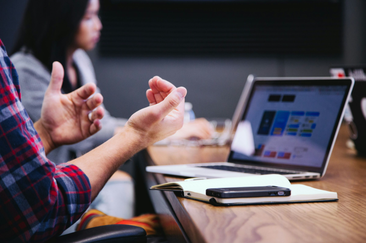 explaining business challenges - person on laptop with hands facing up