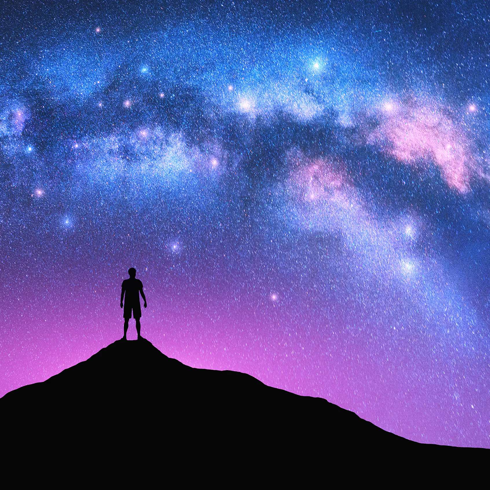 Milky Way arch and man on the mountain peak at starry night. Silhouette of alone guy, pink sky with bright stars